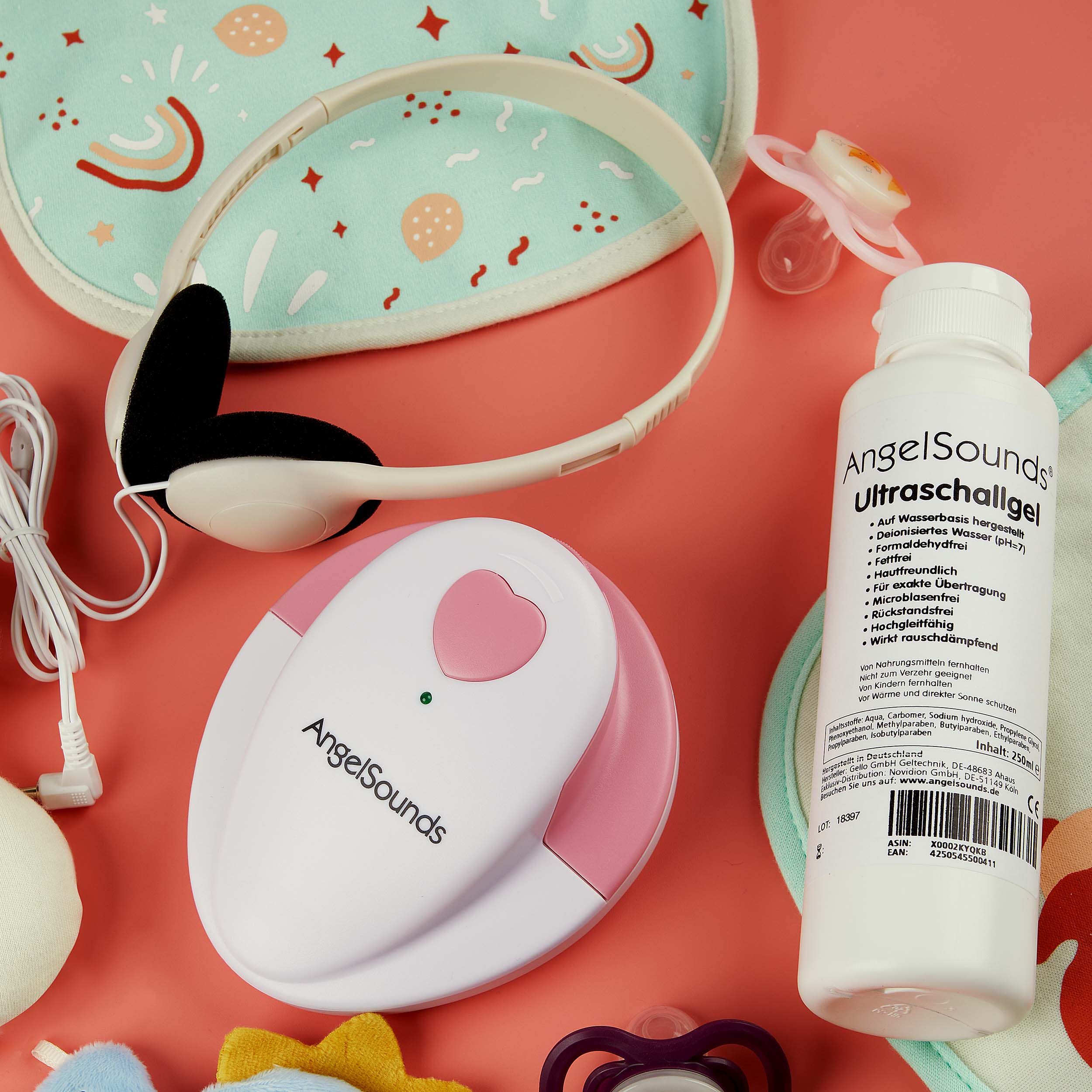 Set mit Fetal-Doppler, Ultraschallgel, Kopfhörer, Schnuller und Lätzchen.