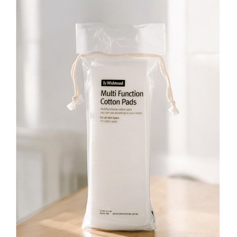 Verpackung mit weißen Baumwoll-Pads. Aufschrift: By Wishtrend Multi Function Cotton Pads. 70 Pads. Transparente Verpackung mit Kordelzug.