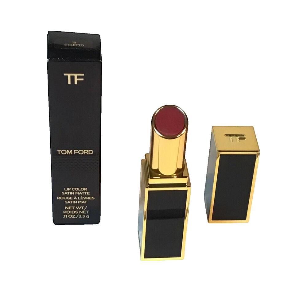 Lippenstift mit goldfarbenem Gehäuse und schwarzer Verpackung. Aufschrift: Tom Ford. Geöffnet, daneben die Kappe.