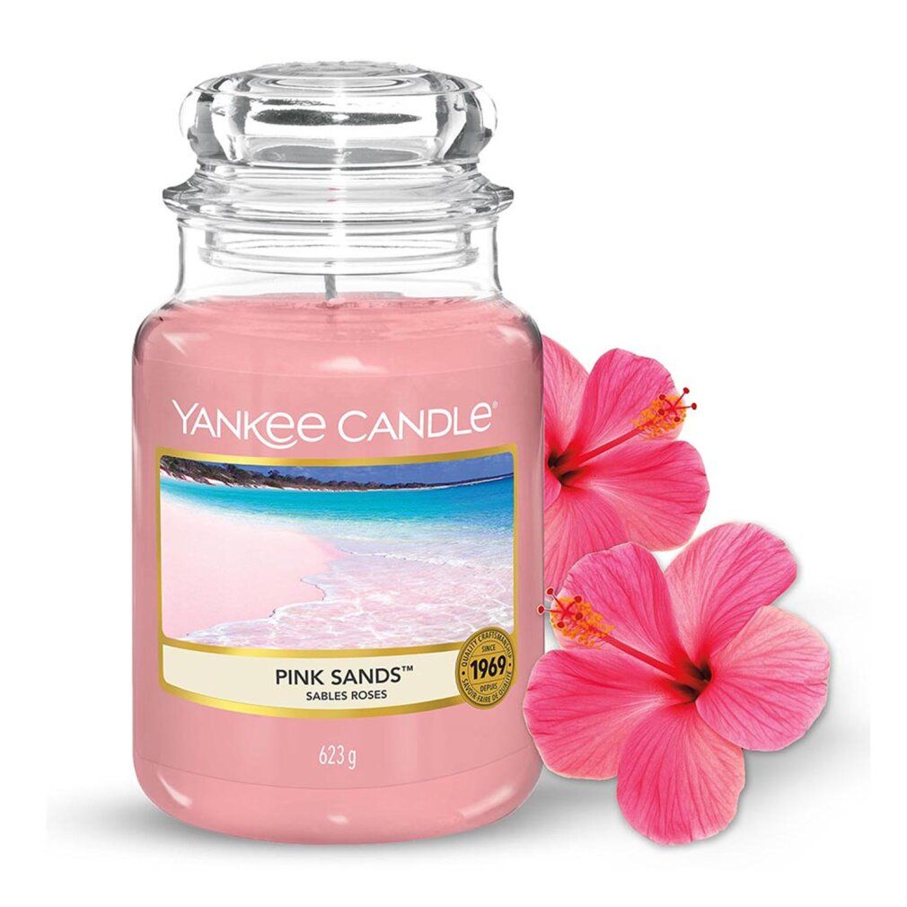 Yankee Candle Pink Sands im Glas. Rosa Wachs, Etikett mit Strandmotiv. Deckel aus Glas. Zwei Hibiskusblüten.