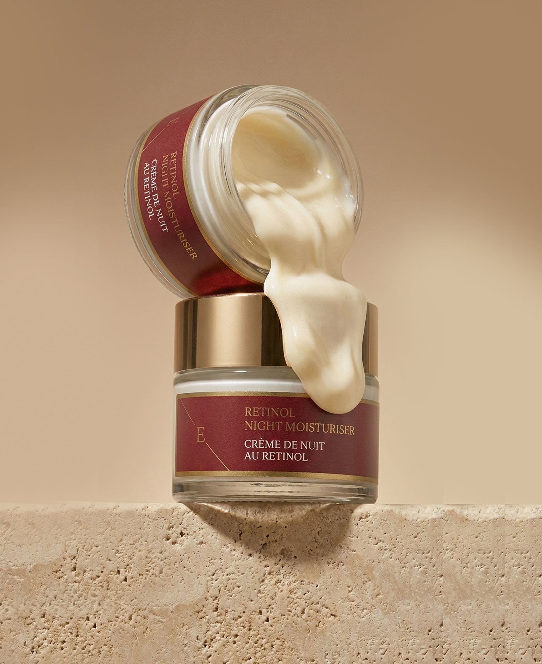 Zwei Cremetiegel, einer geöffnet, Creme fließt heraus. Text: Retinol Night Moisturiser, Crème de Nuit au Rétinol.