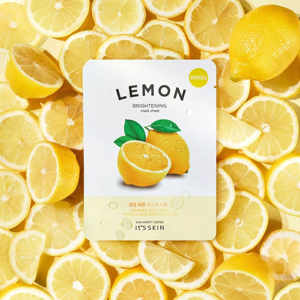 Gesichtsmaske mit Zitrone-Motiv, umgeben von Zitronenscheiben. Aufschrift: LEMON, BRIGHTENING, IT'S SKIN.