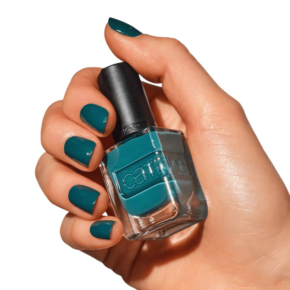 Hand hält Nagellackflasche und lackierte Fingernägel. Der Lack ist dunkelgrün. Der Markenname ist sichtbar.