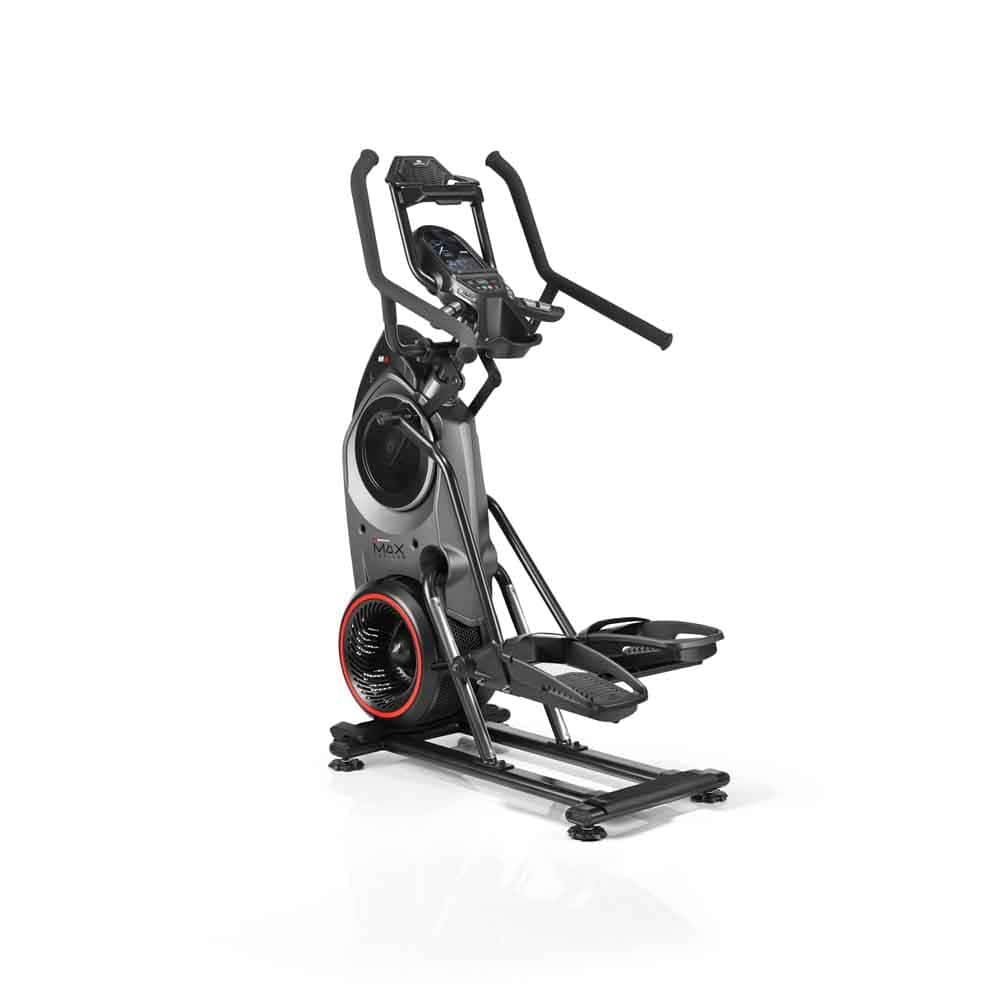 Graues Fitnessgerät mit Pedalen, Griffen und Konsole. Rotes Detail am Schwungrad. Schwarze Basis. Stehende Position.