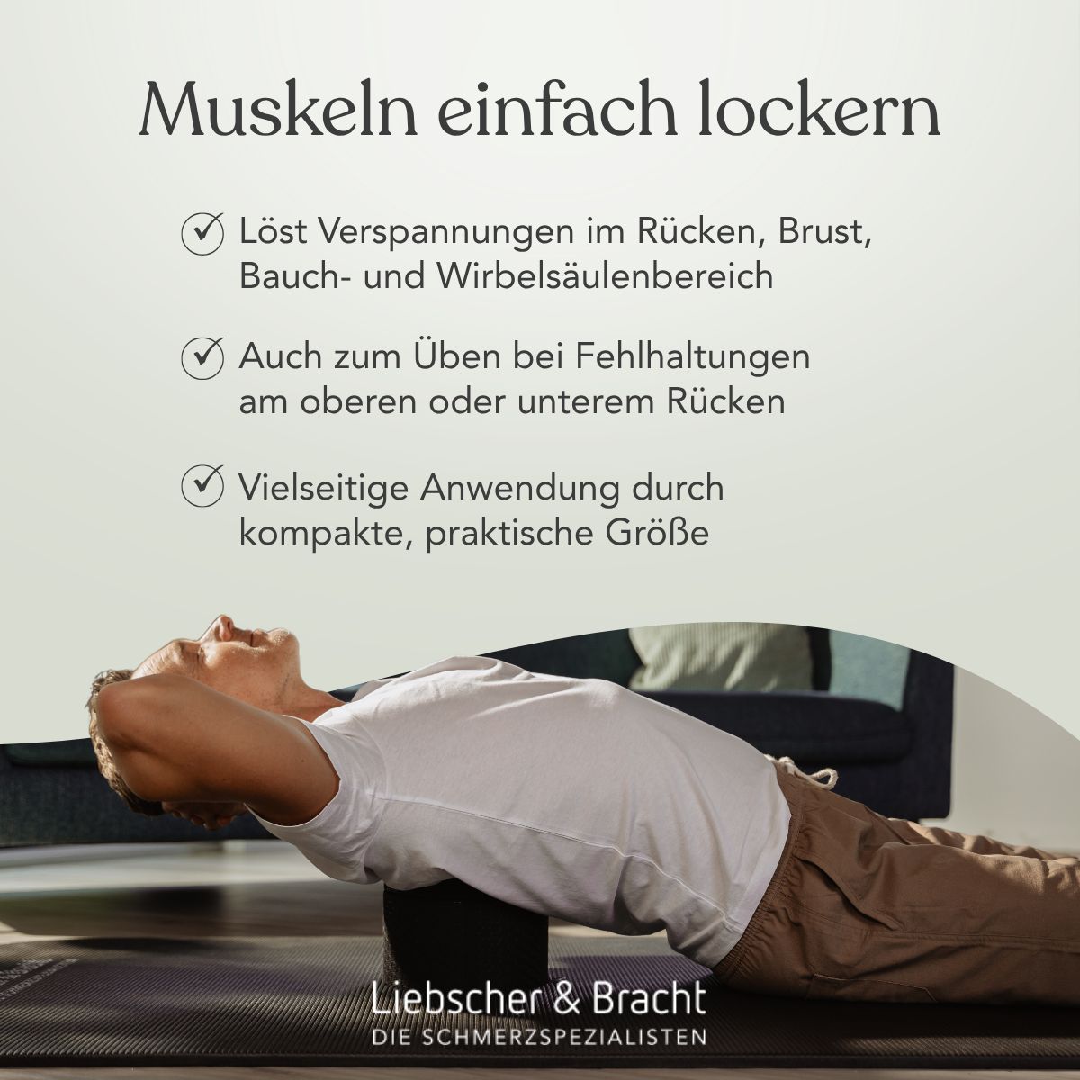 Mann liegt mit dem Rücken auf einem schwarzen Rückenretter zur Lockerung der Wirbelsäule.