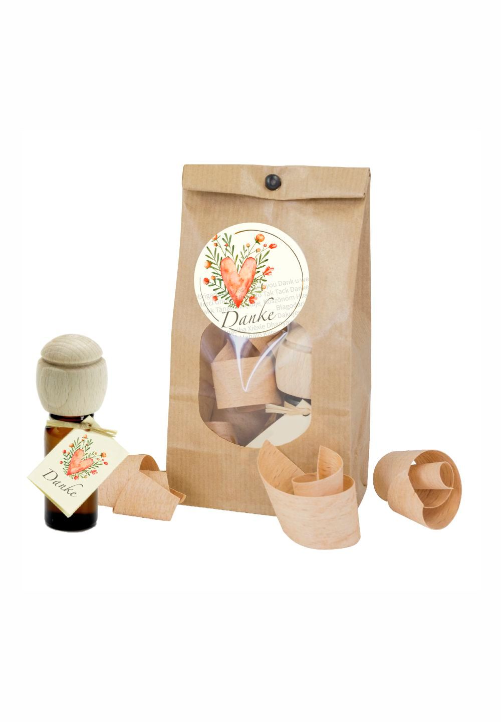 Geschenkset mit brauner Glasflasche, Holzdeckel, Papiertüte und Holzspänen. Etikett mit Herz und "Danke".