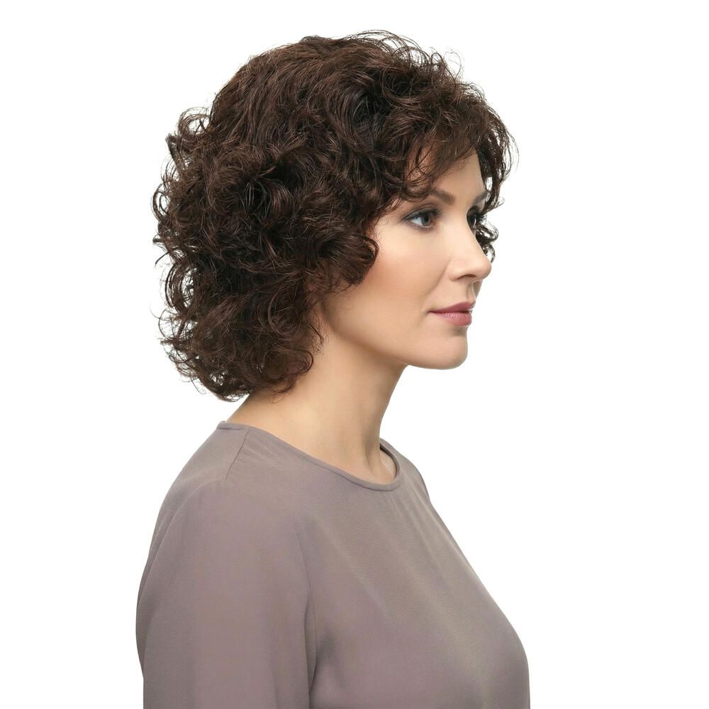 Frau mit brauner, lockiger Perücke. Schulterlanges Haar. Seitenansicht, weißer Hintergrund.