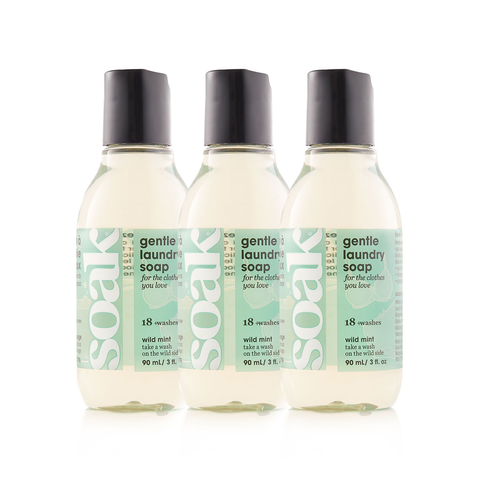 Drei Waschmittelflaschen. Schwarze Deckel, grüne Etiketten mit Text: gentle laundry soap, 18 washes, wild mint, 90 ml.