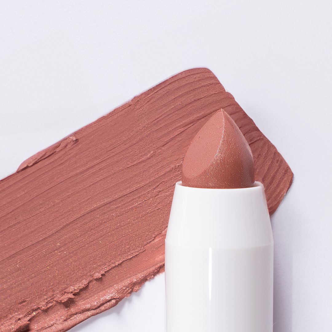 Ein weißer Lippenstift mit brauner Spitze und einem braunen Farbmuster.