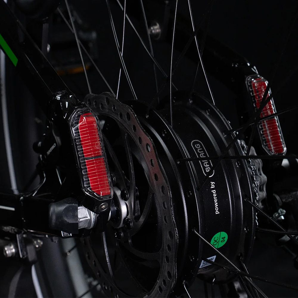 Nahaufnahme der Hinterradbremse und des Motors. Rote Reflektoren und Scheibenbremse. Aufschrift: Powered by Bafang.