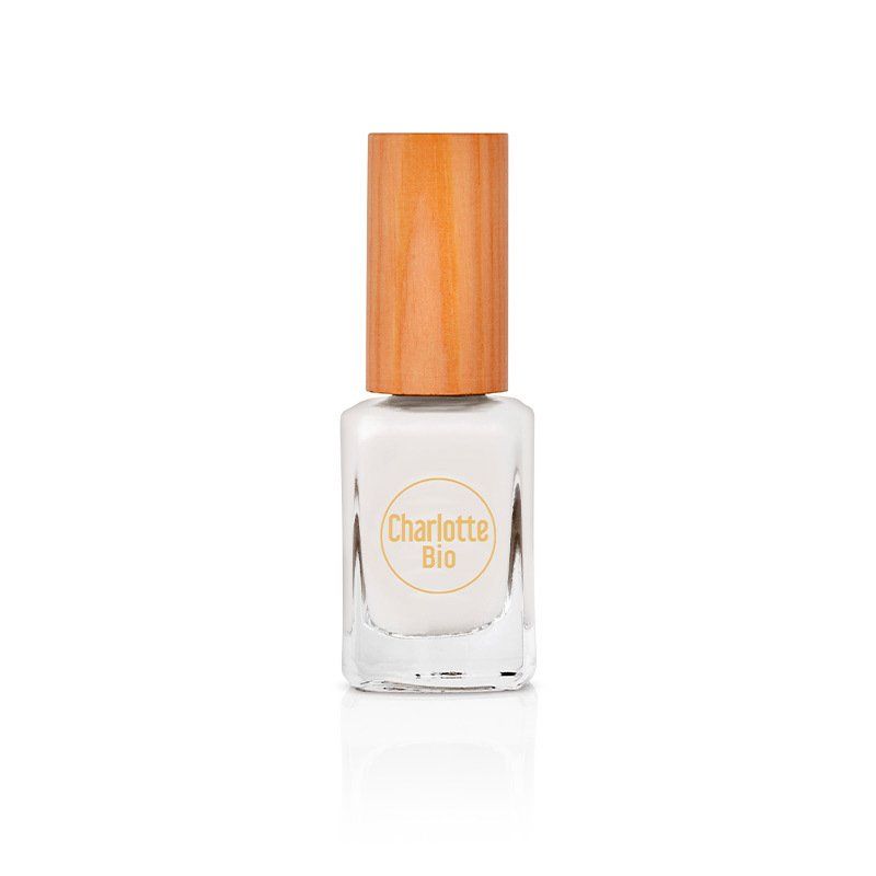 Nagellackflasche mit weißem Inhalt und Holzdeckel. Auf dem Etikett steht "Charlotte Bio".