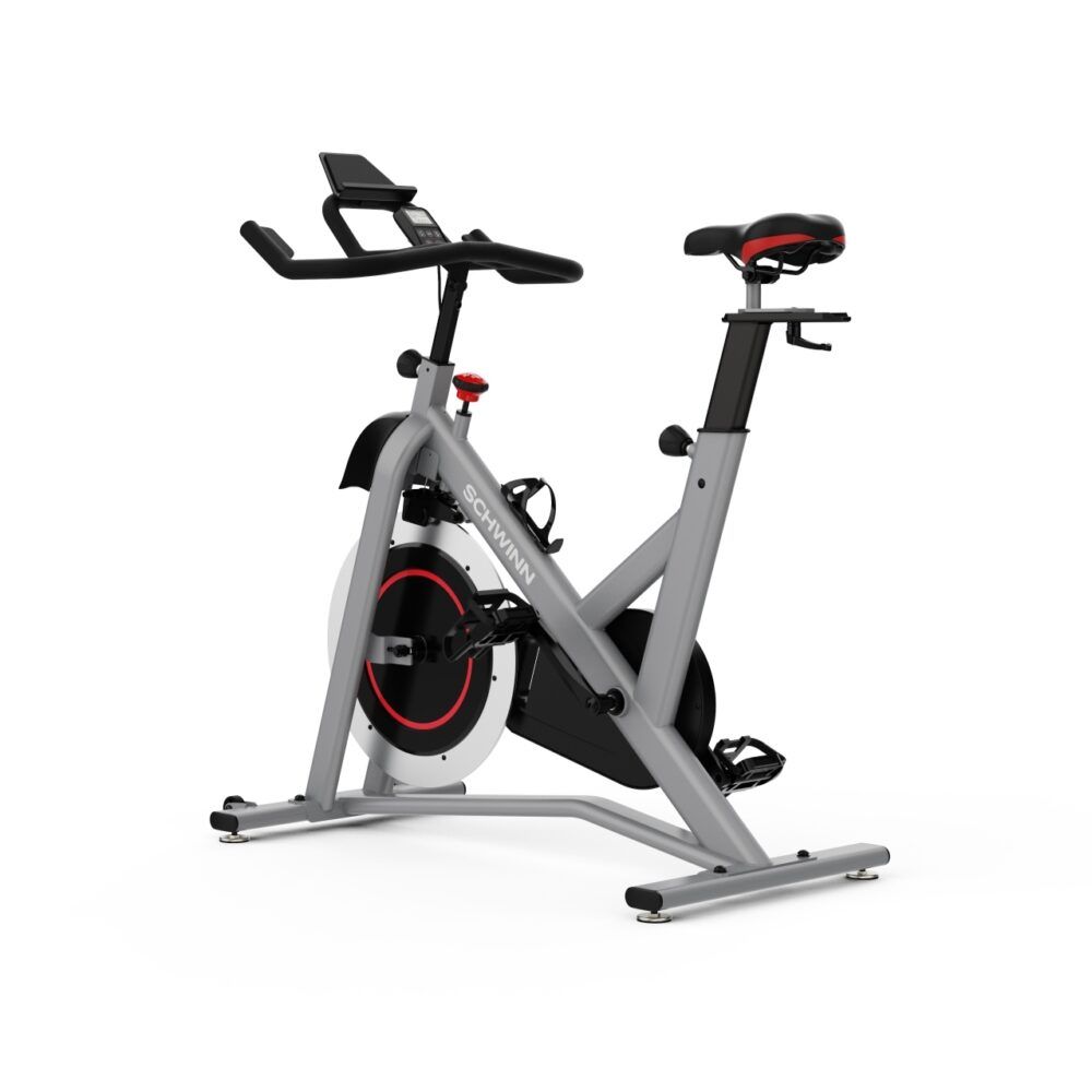 Graues Indoor-Cycle. Sichtbar: Sattel, Lenker, Pedale, Schwungrad. Marke: Schwinn. Roter Akzent am Schwungrad.