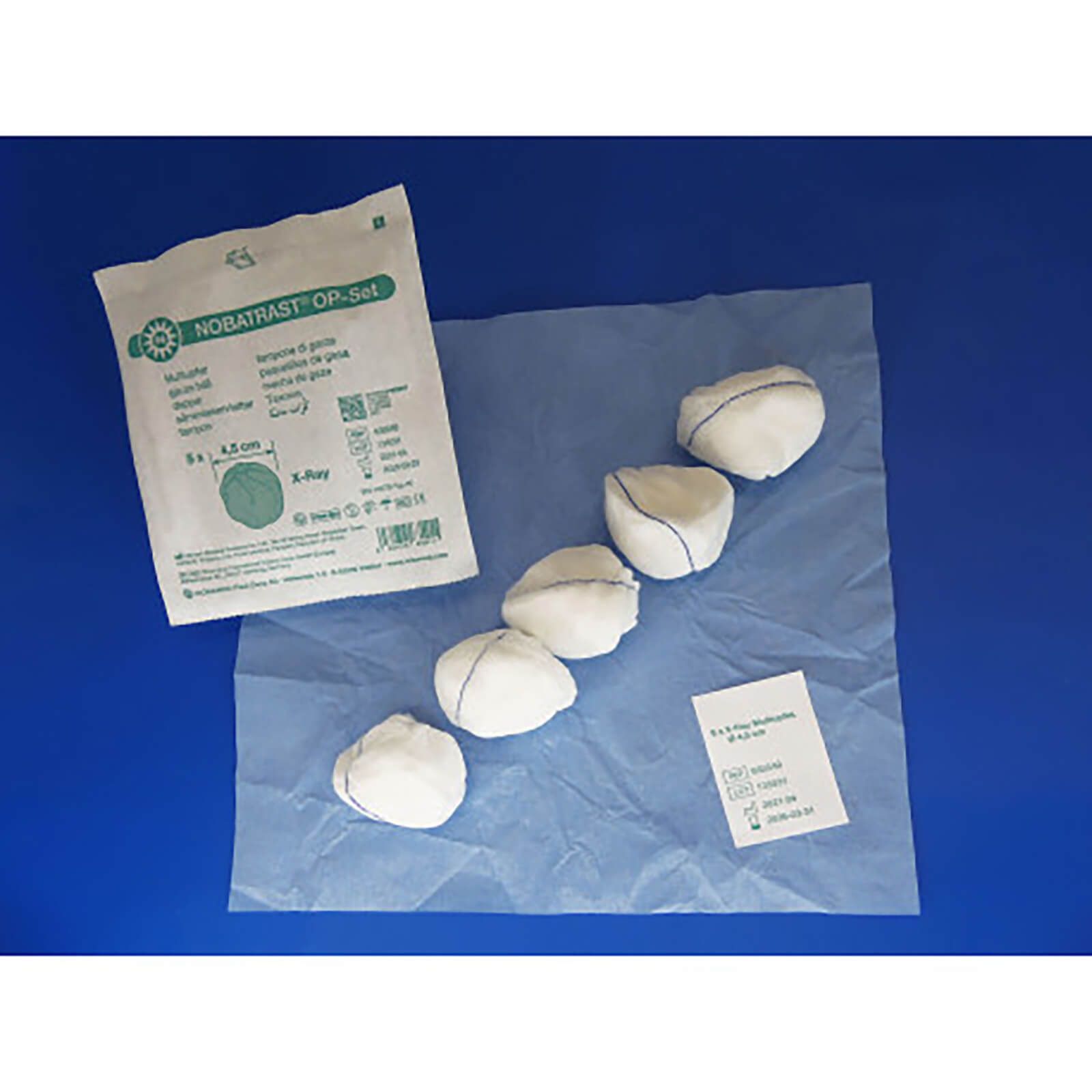 OP-Set mit Mulltupfern. Fünf weiße Tupfer auf blauem Untergrund. Verpackung mit Produktinformationen.