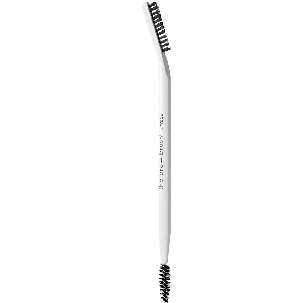Weißer Augenbrauenbürste mit schwarzem Borstenkopf. Der Stiel ist mit "the brow brush" und "wbc" beschriftet.
