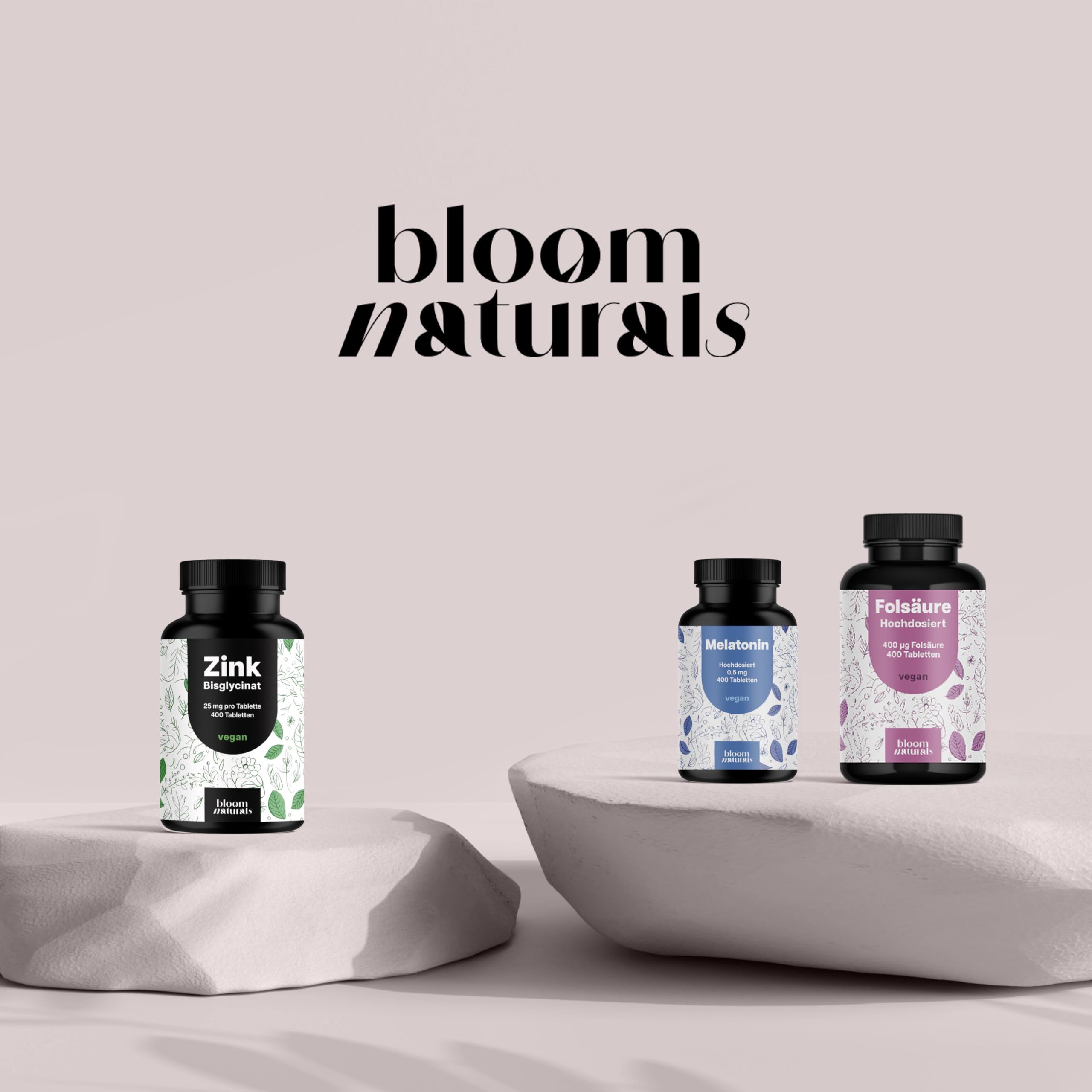 Drei Bloom Naturals® Dosen: Zink Bisglycinat (grün), Melatonin (blau), Folsäure (lila).