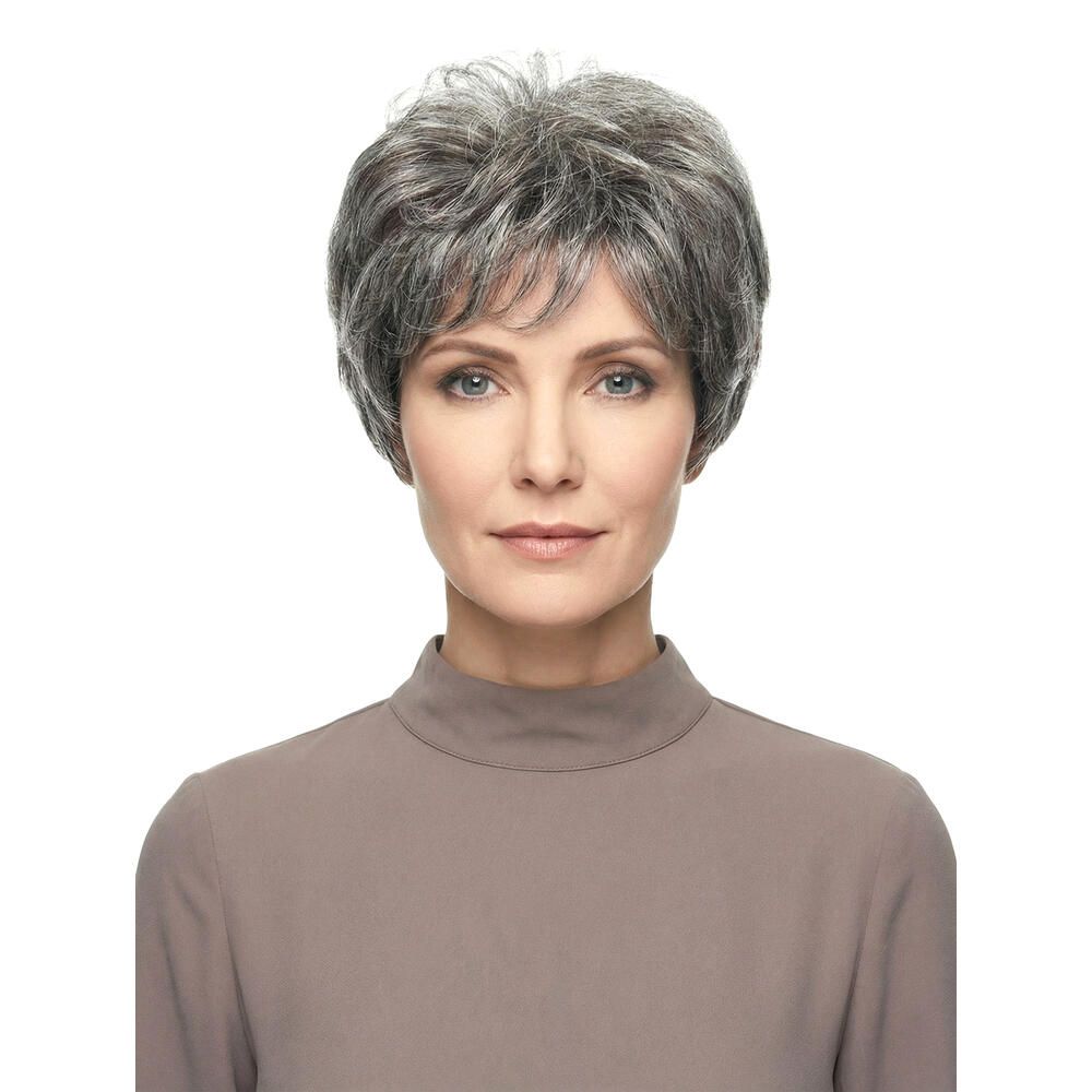 Kurzhaarperücke mit grauen Strähnen. Frontale Ansicht einer Frau mit der Perücke. Sie trägt ein braunes Oberteil.
