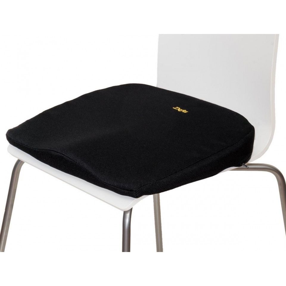 Schwarzes Keilkissen auf einem weißen Stuhl. Goldfarbenes Logo sichtbar. Quadratische Form mit abgerundeten Ecken.