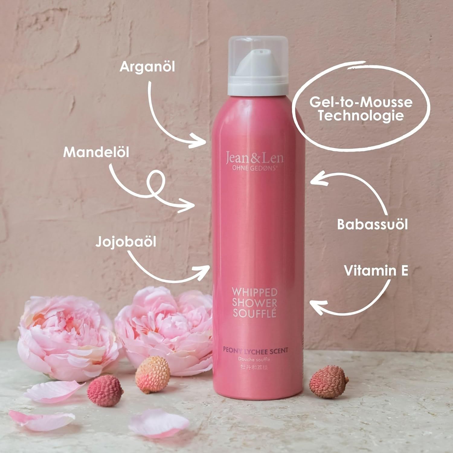 Rosa Flasche Whipped Shower Soufflé von Jean & Len. Mit Pfeilen versehen, die Inhaltsstoffe wie Arganöl, Mandelöl, Jojobaöl, Babassuöl und Vitamin E zeigen.