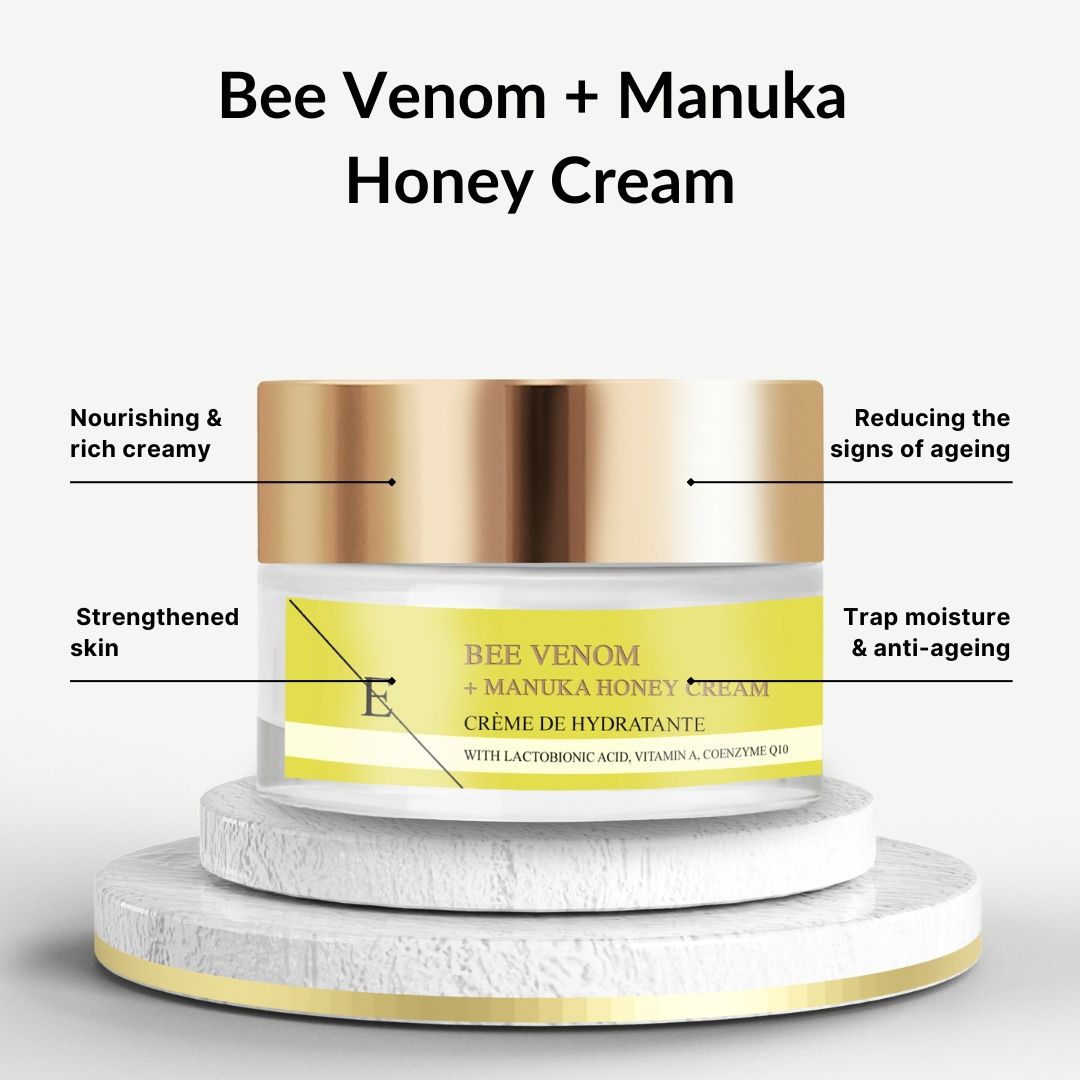 Creme-Glas mit goldenem Deckel. Gelbes Etikett mit Schriftzug: Bee Venom + Manuka Honey Cream. Auf Podest.