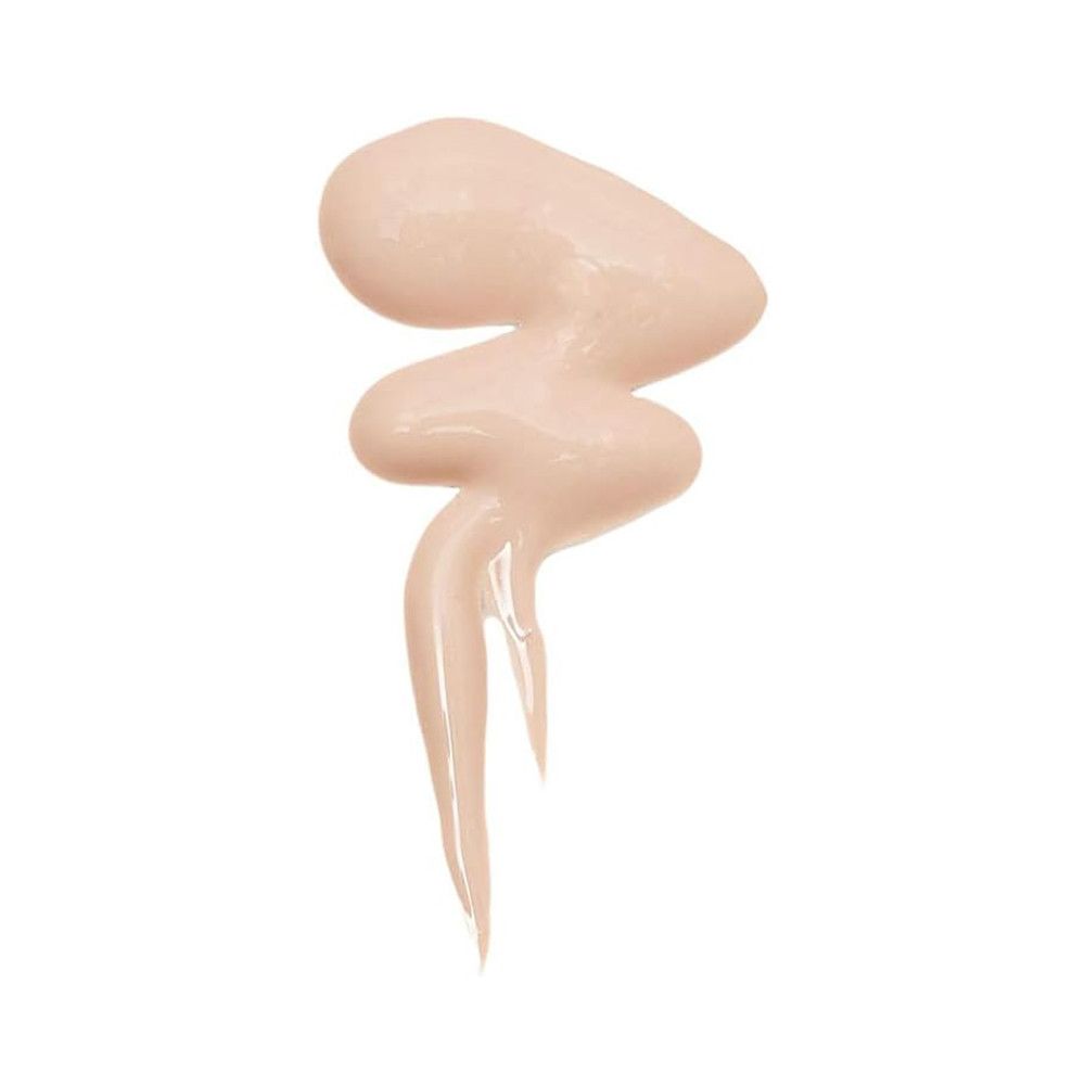 Ein flüssiger Make-up-Fleck in einem hellen Hautton, der sich in einer geschwungenen Form über einen weißen Hintergrund ergießt.