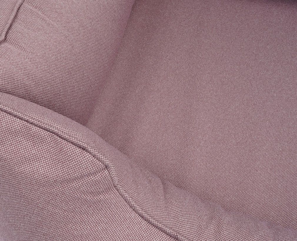Nahaufnahme des rosa Hundebetts. Stoffstruktur und Nähte sichtbar. Eckdetail.