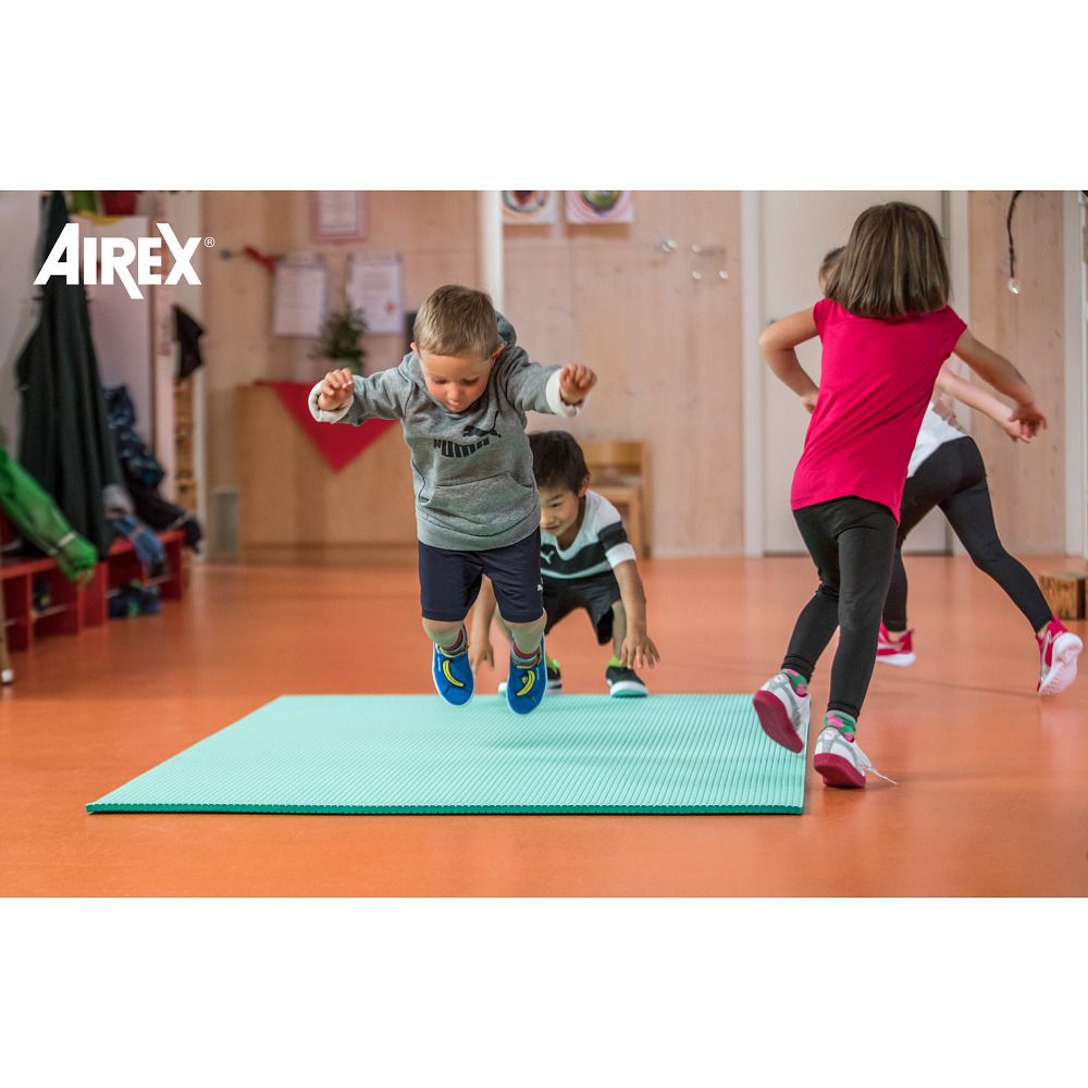 Türkisgrüne Gymnastikmatte. Kinder springen darauf. Airex-Logo links oben.