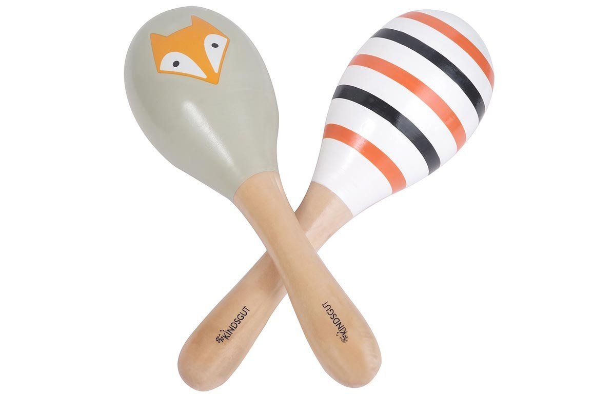 Zwei Rasseln mit Holzgriff. Eine grau mit Fuchsmotiv, die andere weiß mit Streifen in Schwarz und Orange. Kindsgut-Logo.