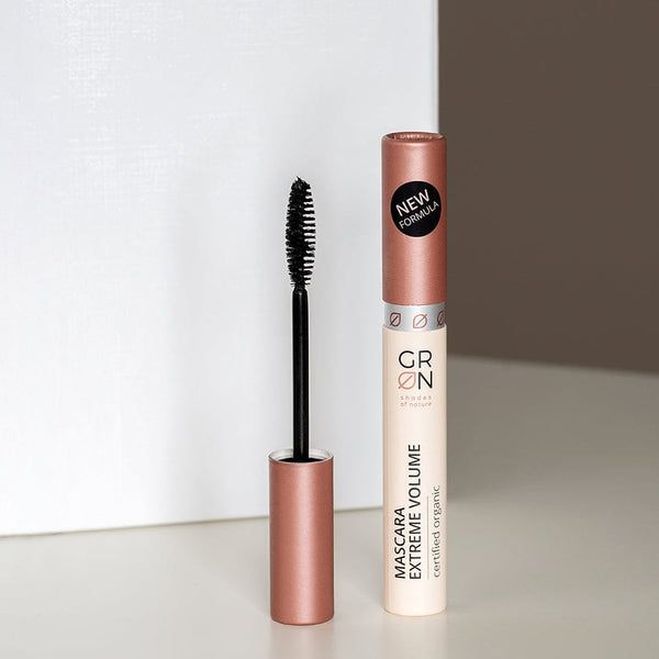 Mascara-Tube und Bürste. Tube mit Schriftzug: GRN Mascara Extreme Volume. Aufkleber: NEW FORMULA. Bürste mit schwarzen Borsten.