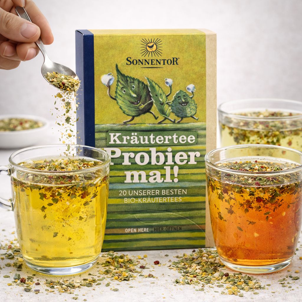 SonnenTor Kräutertee Probier mal! Zwei Gläser Tee und eine Schale mit losem Tee.