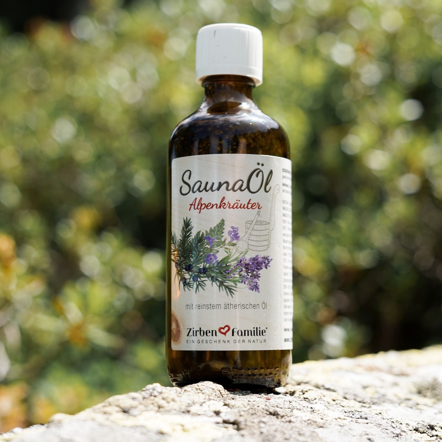 Braune Flasche mit weißem Deckel. Etikett mit Produktname und Illustration. Auf einem Stein platziert.