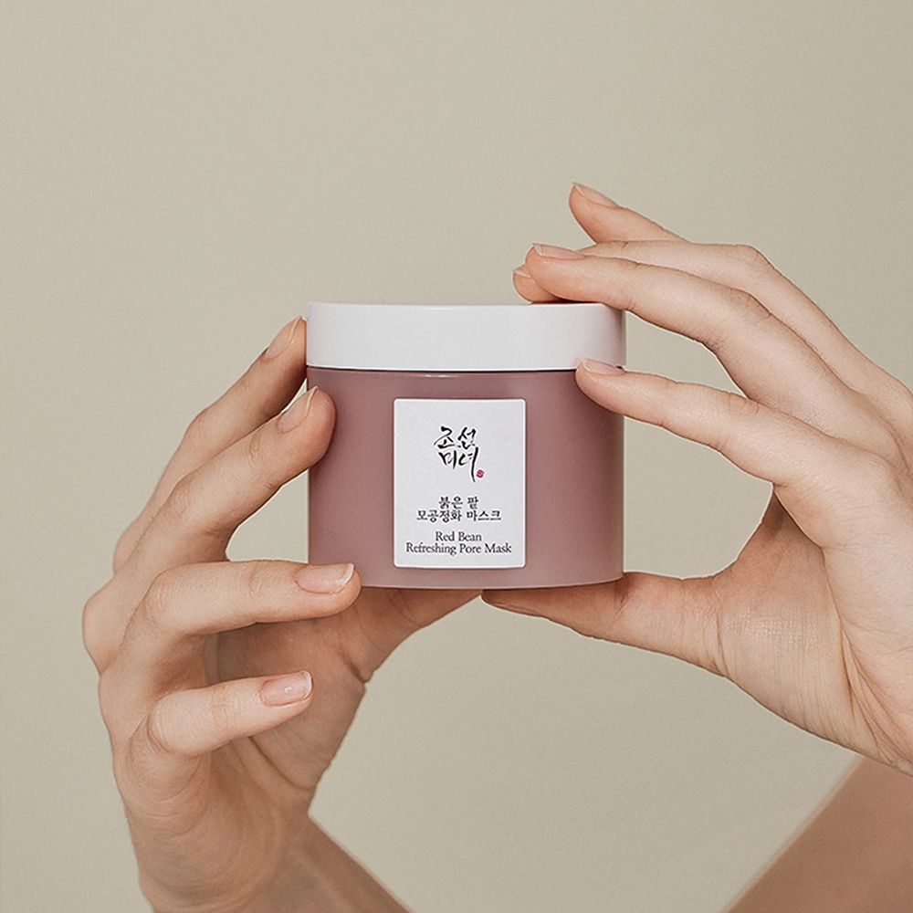 Hände halten einen Behälter der Beauty of Joseon Red Bean Refreshing Pore Mask.