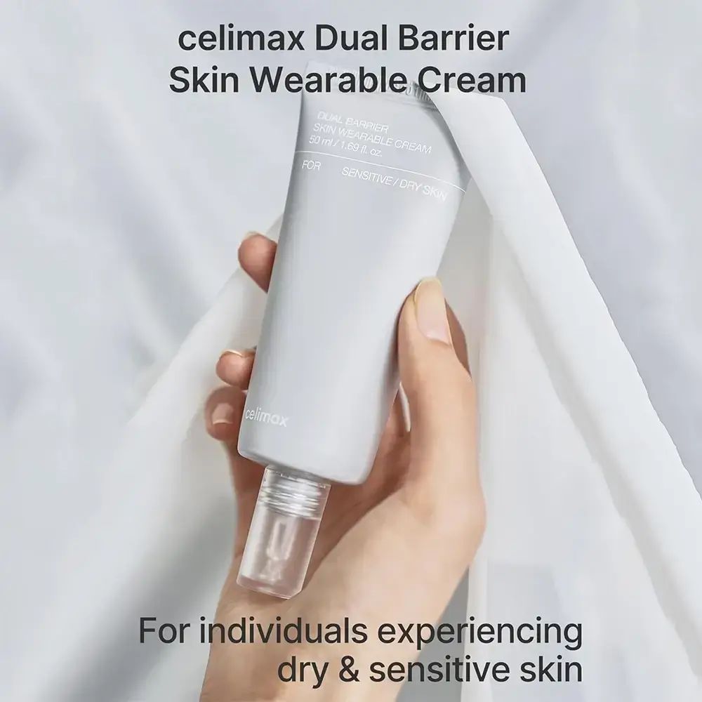 Hand hält graue Tube. Aufschrift: celimax Dual Barrier Skin Wearable Cream. Für trockene und empfindliche Haut.