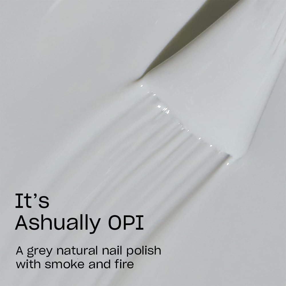 Nahaufnahme eines Nagellackpinsels. Auf dem Pinsel steht It's Ashually OPI. Text: grauer Nagellack mit Rauch und Feuer.