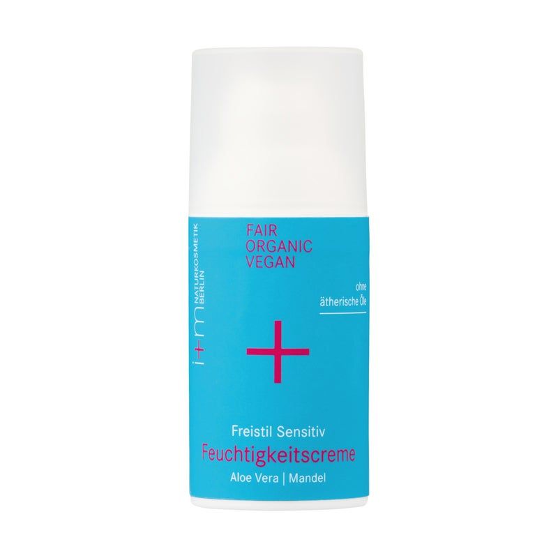 Zylindrische Flasche mit blauem Etikett. Text: Freistil Sensitiv Feuchtigkeitscreme, Aloe Vera, Mandel. Logo: Pluszeichen.