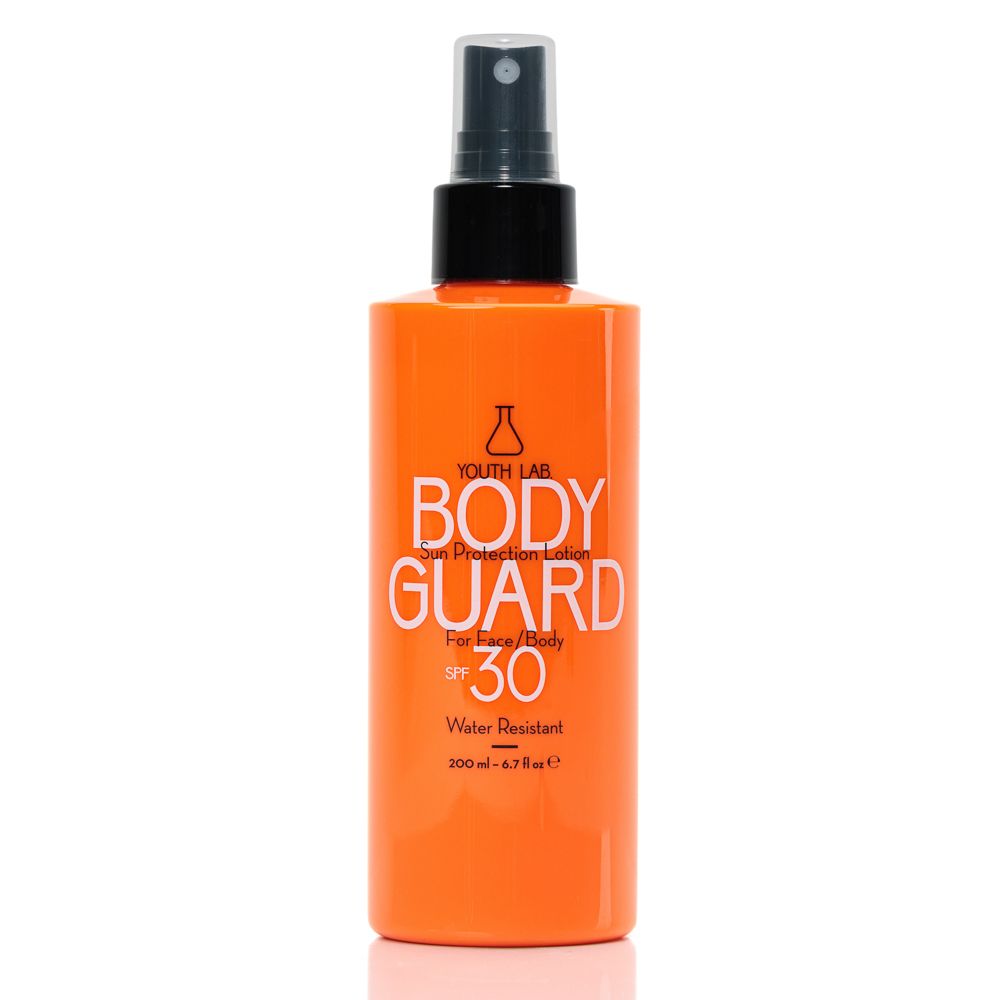 Orangefarbene Sprühflasche mit schwarzem Sprühkopf. Aufschrift: BODY GUARD SPF 30, Water Resistant. Marke: YOUTH LAB.
