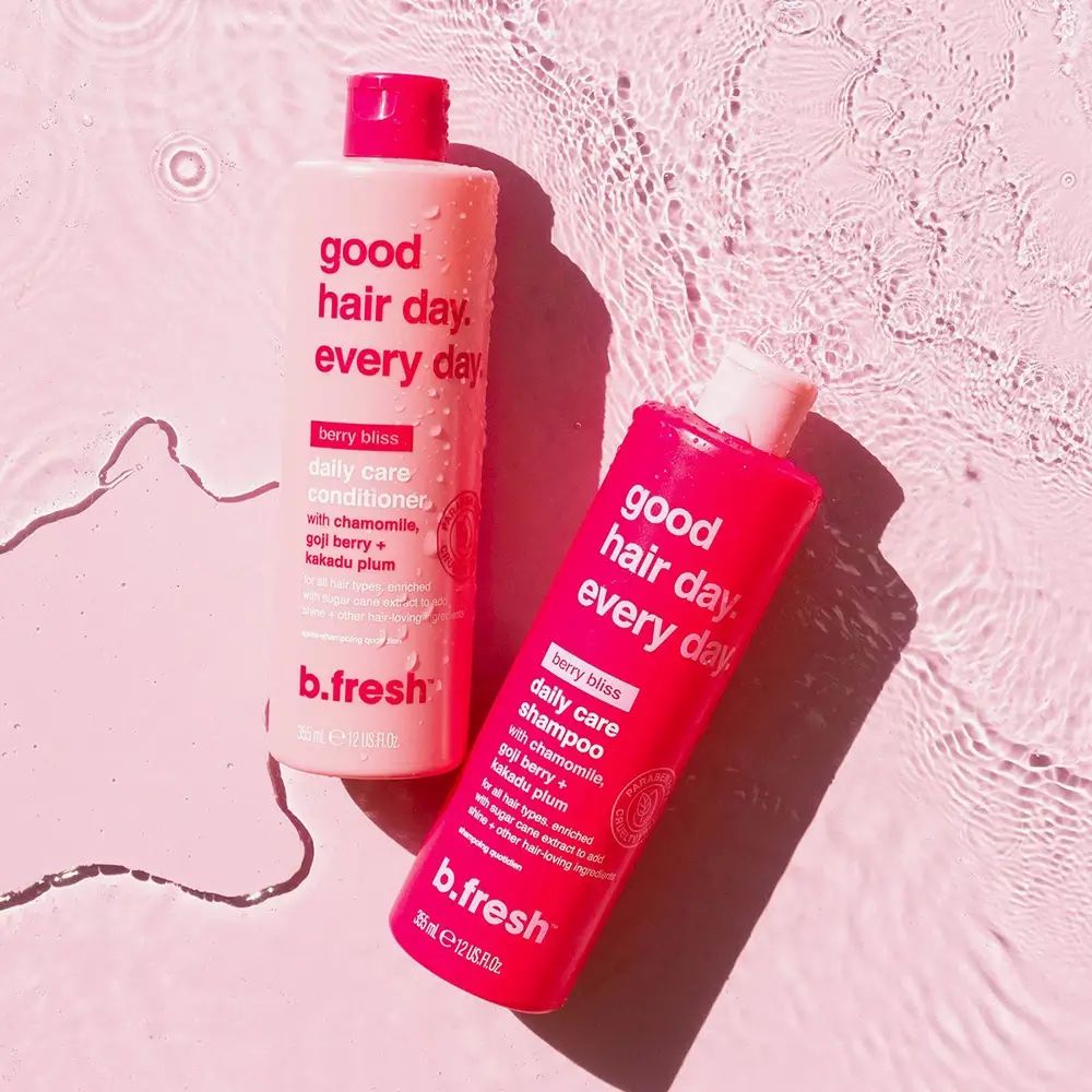 Zwei Shampoo-Flaschen im Wasser. Text: Good Hair Day. Every Day. Berry Bliss Daily Care Shampoo. Marke: b.fresh. Paraben Free, Cruelty Free.