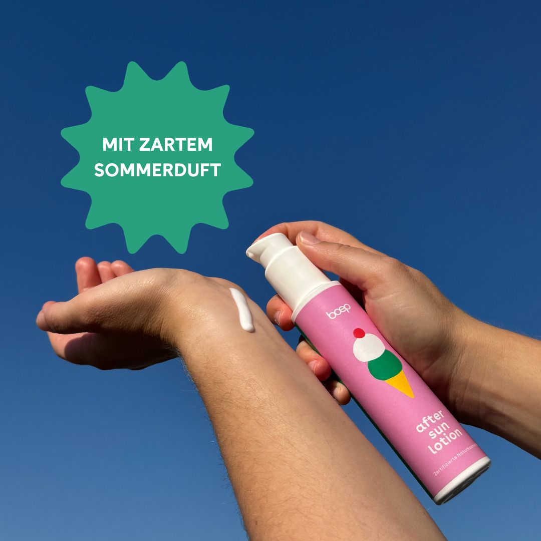 Person hält rosa Flasche mit weißem Pumpkopf. Auf Hand aufgetragene Lotion. Blauer Himmel im Hintergrund.