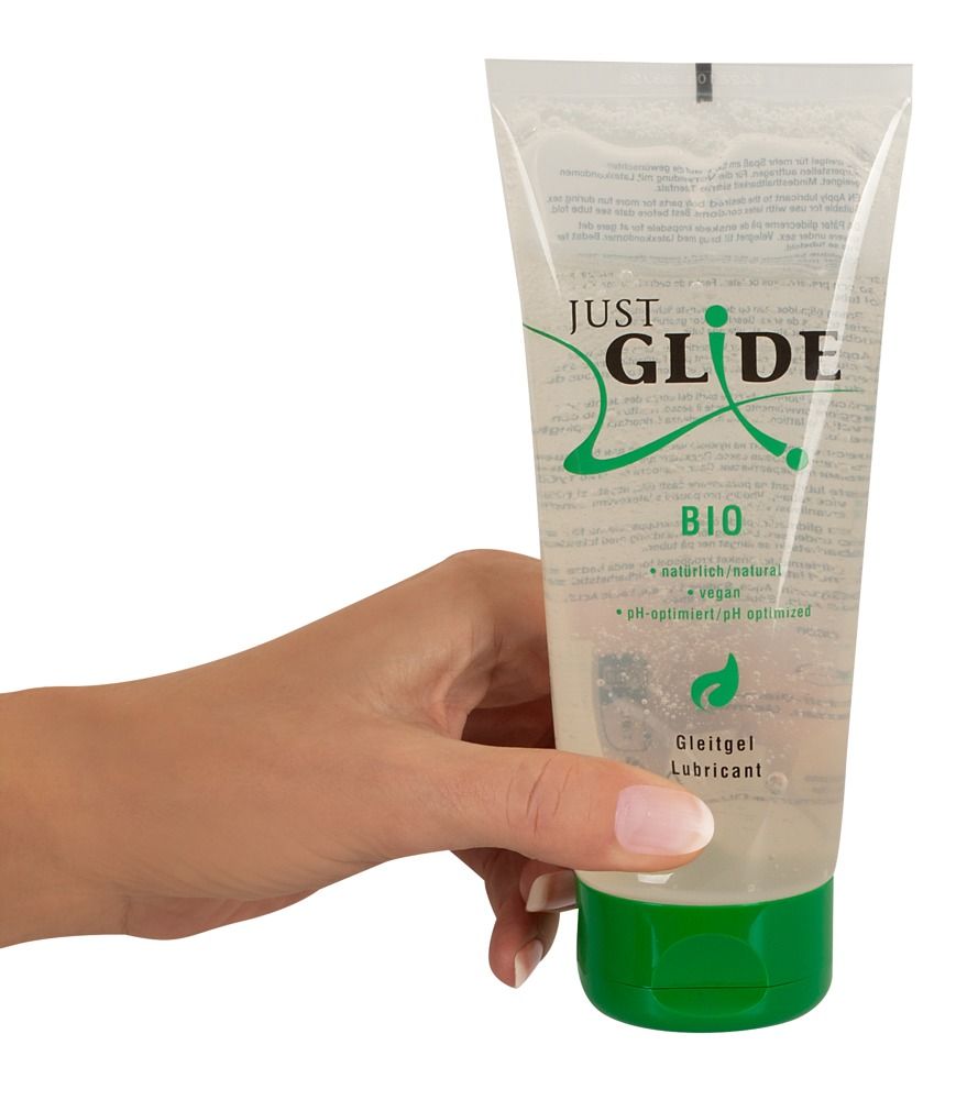 Hand hält eine Tube mit transparentem Gel und grünem Verschluss. Aufschrift: Just Glide Bio, Gleitgel.