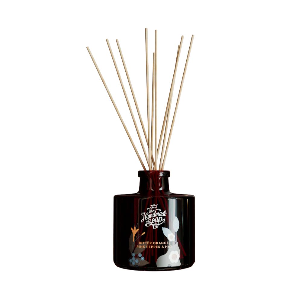 Braune Glasflasche mit Holzstäbchen. Aufschrift: The Handmade Soap Co. Bitter Orange, Pink Pepper & Honey. Abbildung eines Hasen.