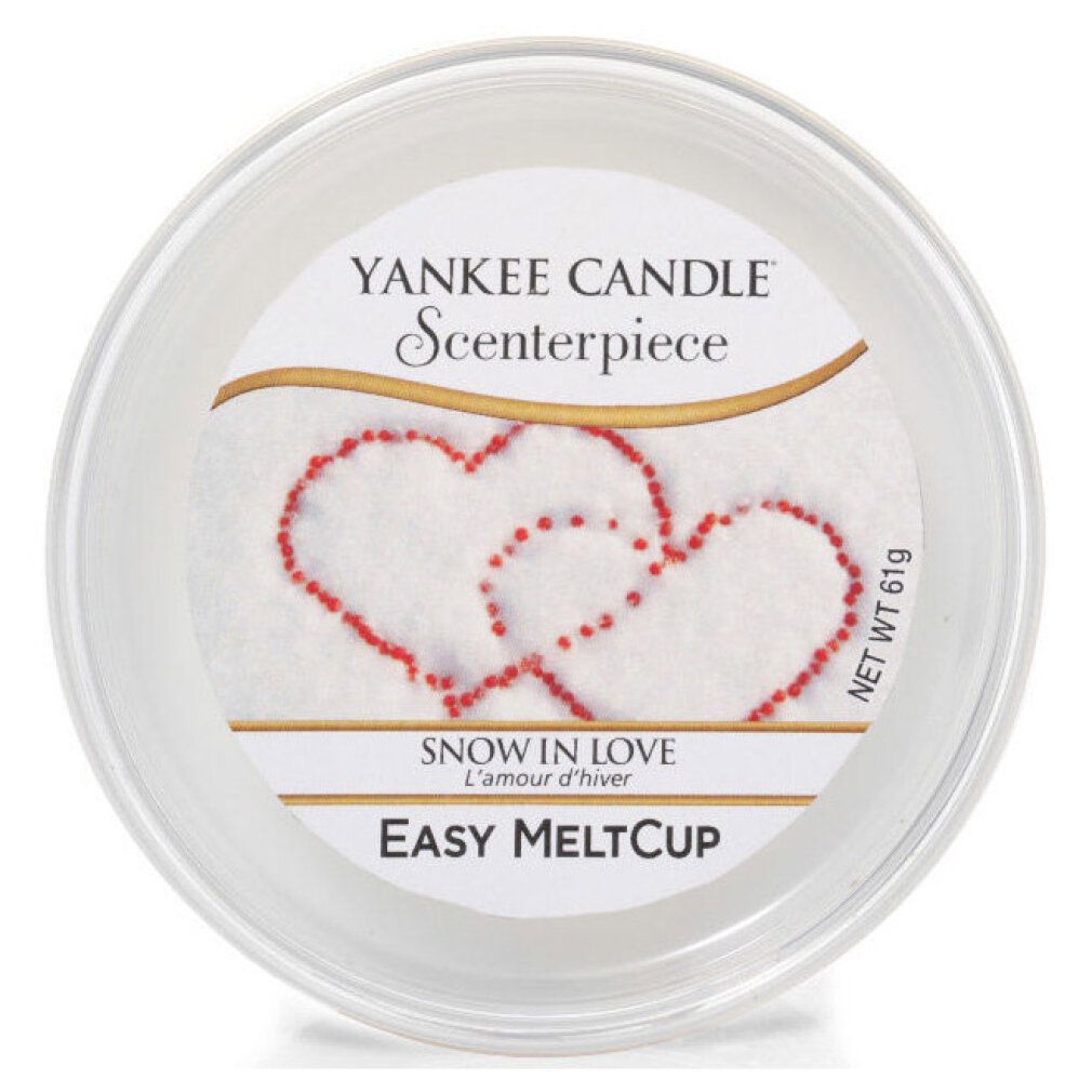 Runde, transparente Wachs-Schale. Aufschrift: Yankee Candle, Scenterpiece, Snow in Love, Easy MeltCup. Rote Herz-Dekoration.