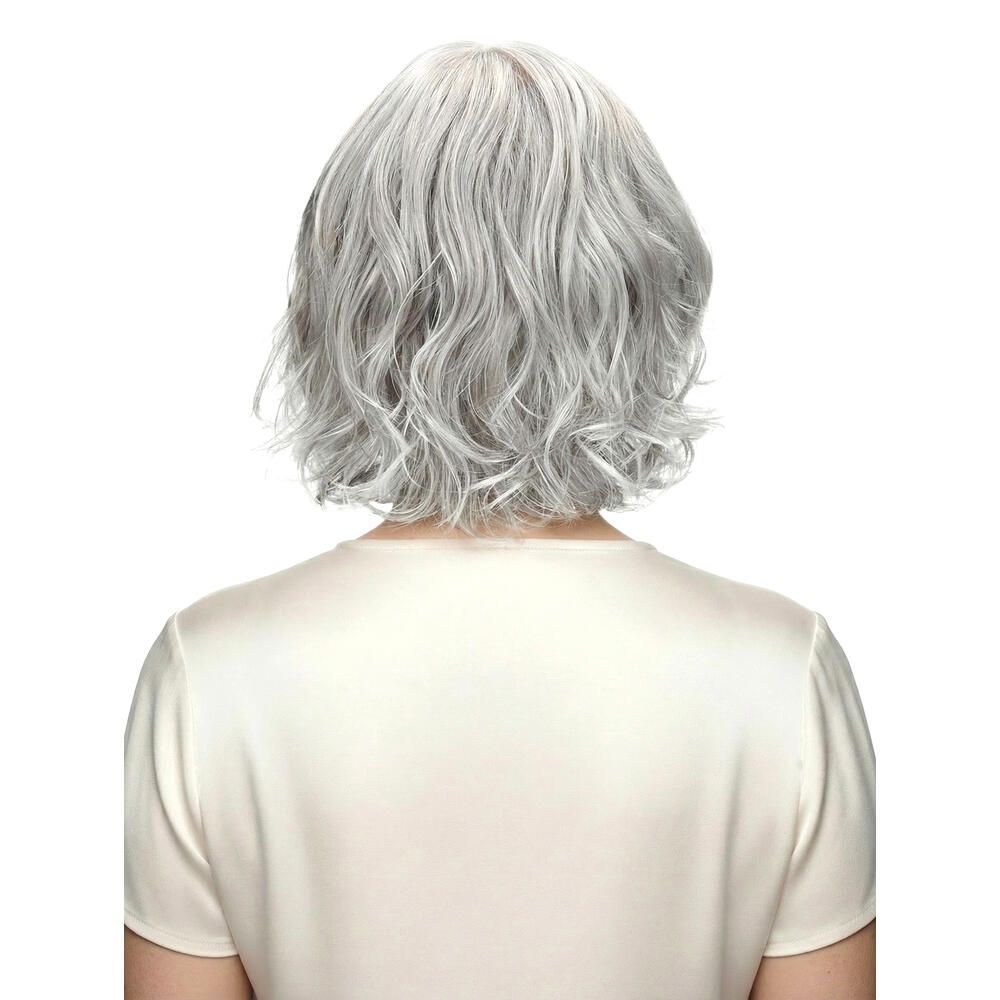 Perücke Capri, graues, welliges Haar. Frau von hinten, helles Oberteil.