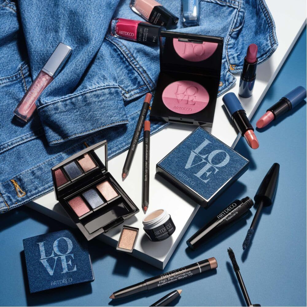 Verschiedene Artdeco Kosmetikprodukte auf blauem Hintergrund. Enthalten Lidschatten, Lippenstifte, Mascara und mehr.