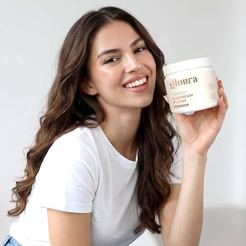 Frau hält weißen Behälter mit Aufschrift Gloura. Sie lächelt in die Kamera.