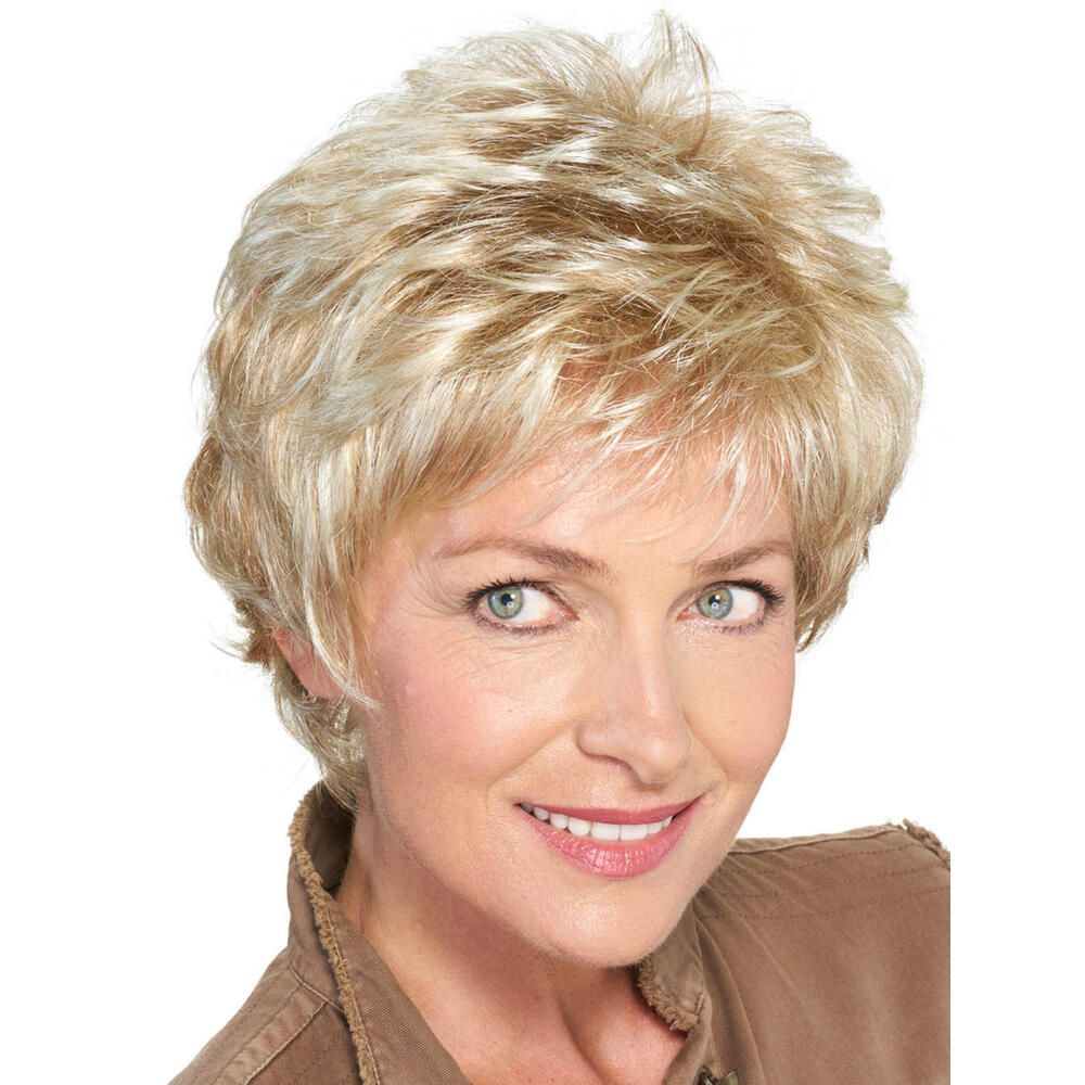 Kurzhaarperücke, blond mit Strähnen, von vorne. Frau mit brauner Jacke, lächelnd.