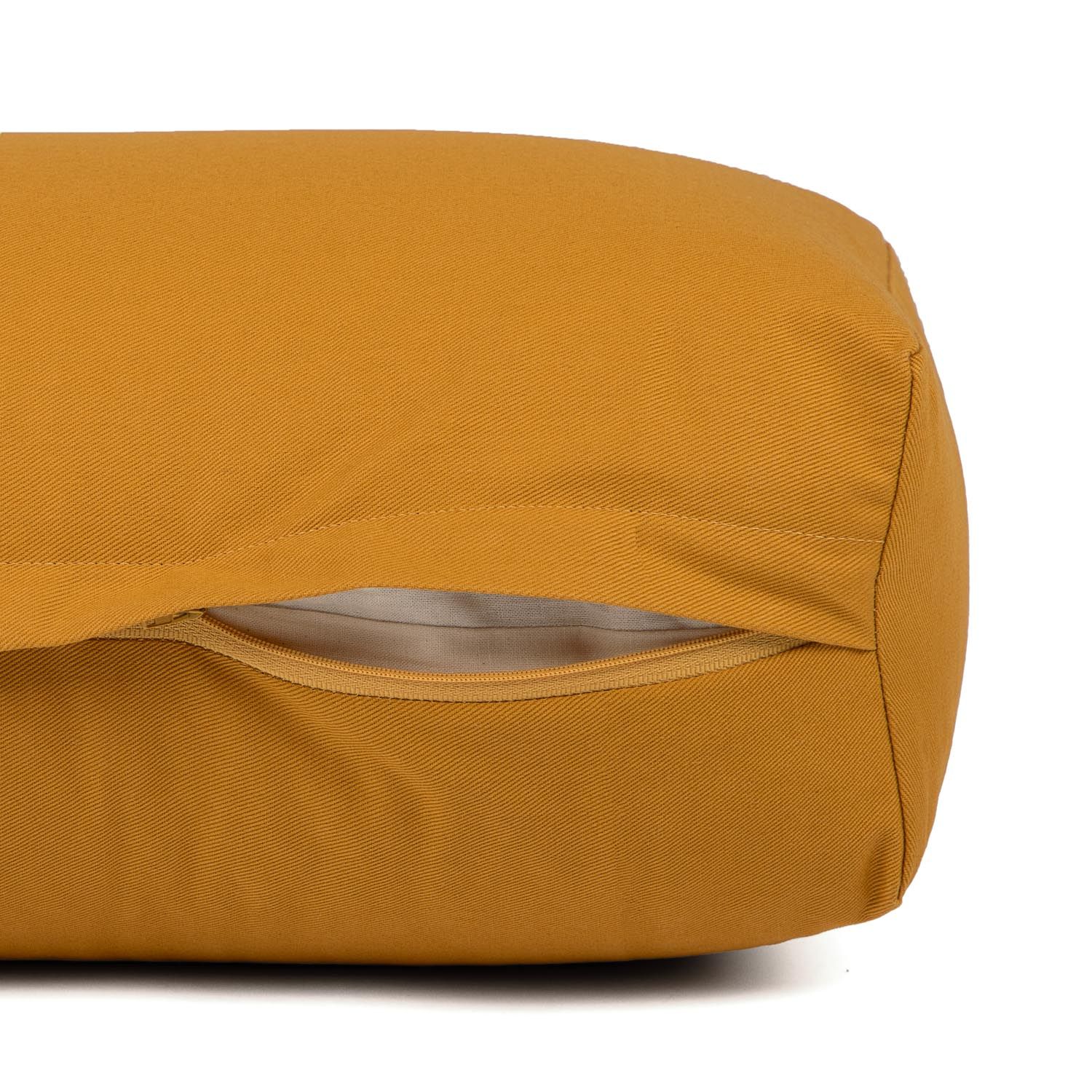 Nahaufnahme des Reißverschlusses an einem senfgelben Yoga-Bolster.