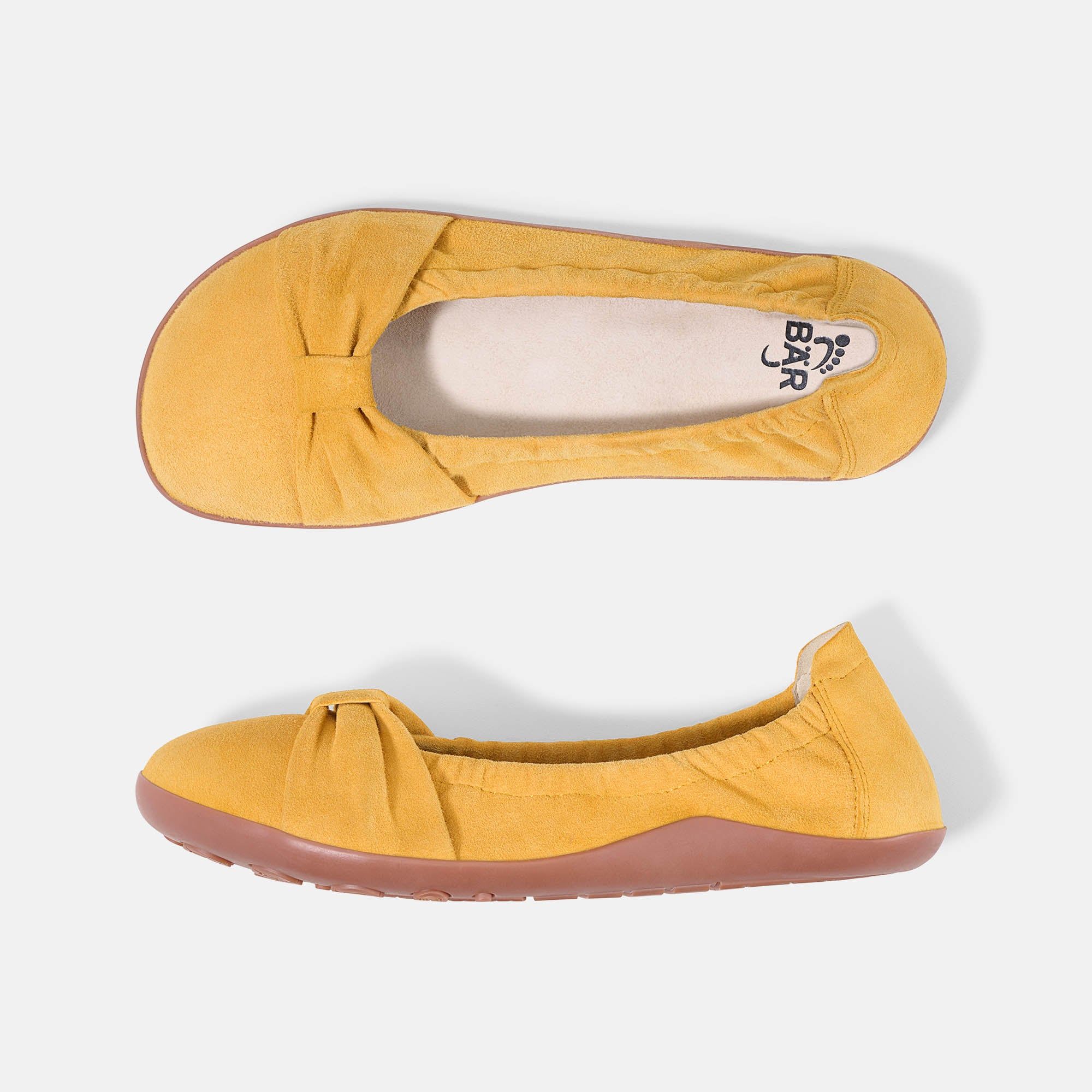 Zwei gelbe Ballerinas. Wildleder, runde Zehen, Schleife vorne. Rosa Sohle. Marke BÄR. Draufsicht.