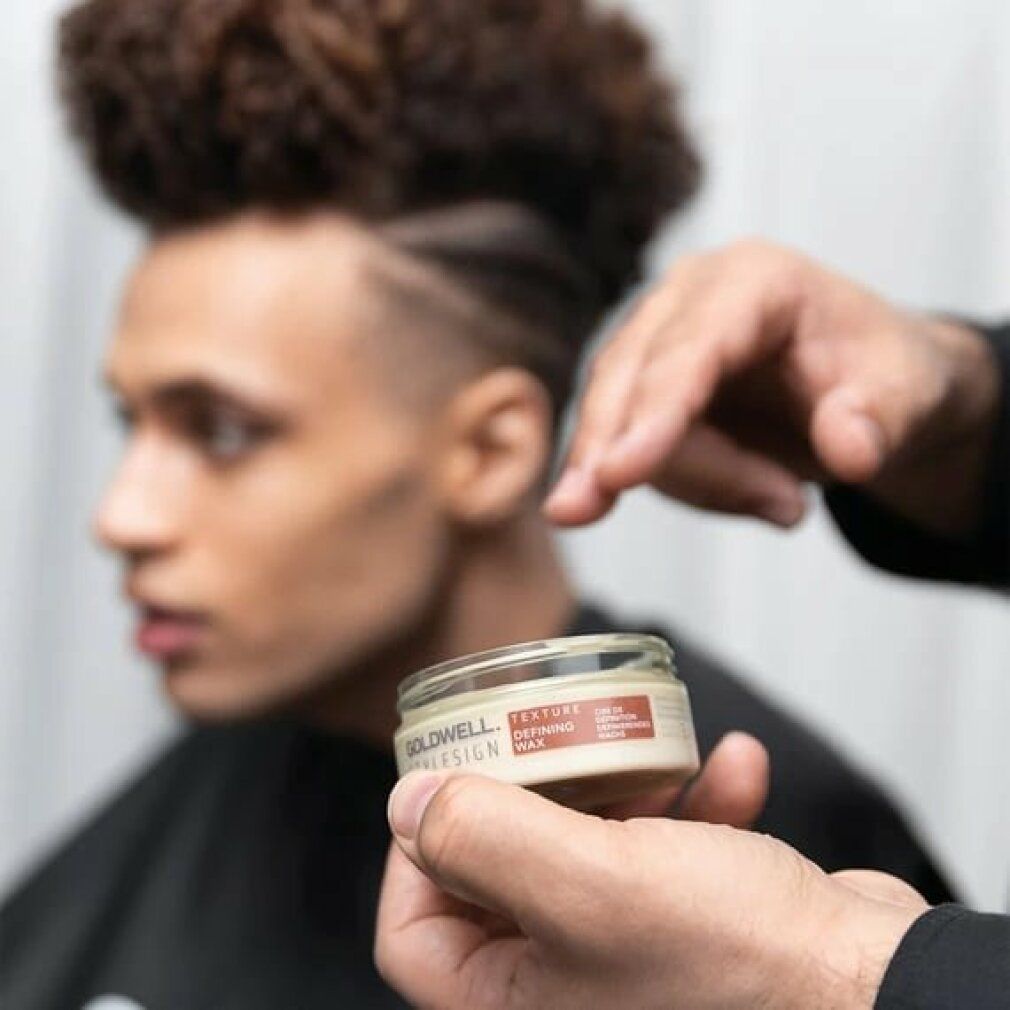 Goldwell Stylesign Texture Definierendes Wachs. Dose in der Hand. Person hält das Produkt vor einem Mann mit Frisur.