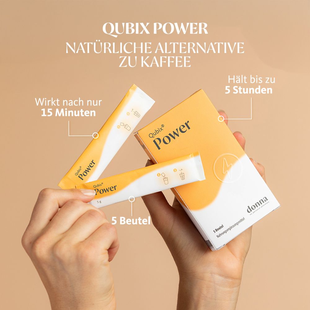 Hände halten eine Schachtel und zwei Beutel Qubix Power. Weiß-gelbe Verpackung. Aufschrift Power.