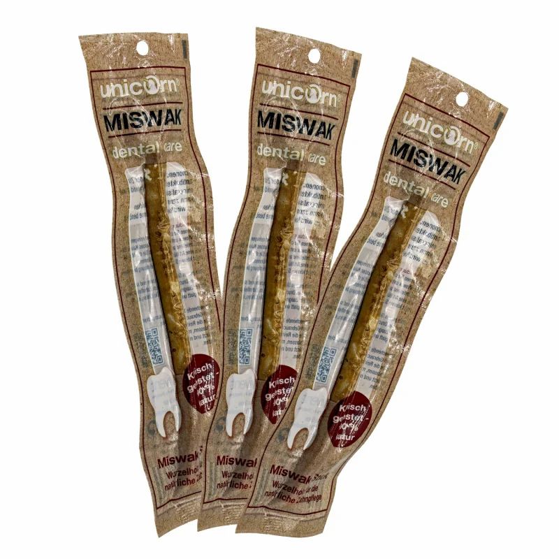 Drei verpackte Miswak Zahnpflegehölzer. Die Verpackung zeigt den Markennamen und Produktbezeichnung. Holzfarbenes Produkt.