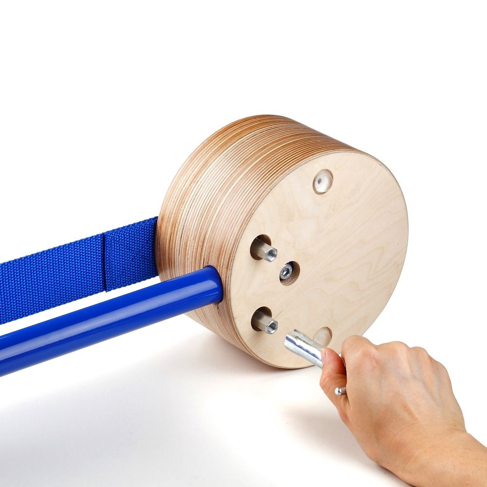 Runder Holzsockel mit blauem Gurtband und blauer Stange. Person hält Werkzeug. Auf weißem Hintergrund.